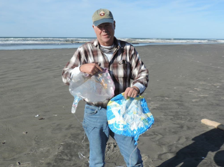 Russ Lewis with two balloons he found on the Washington coast.