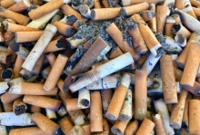 Pile of cigarette butts on a beach.