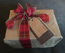 A present wrapped in brown paper bag and reusable fabric ribbon.