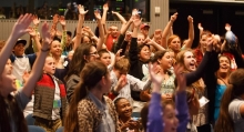 Students raise their hands at a plastic pollution summit at Monterey Bay Aquarium