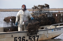 A man stands on a boat near derelict crab traps.