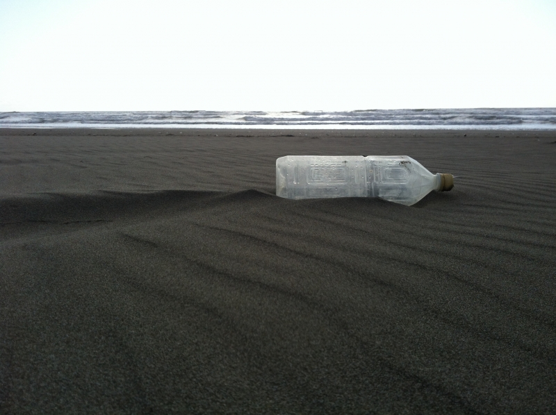 A plastic bottle on a beach.