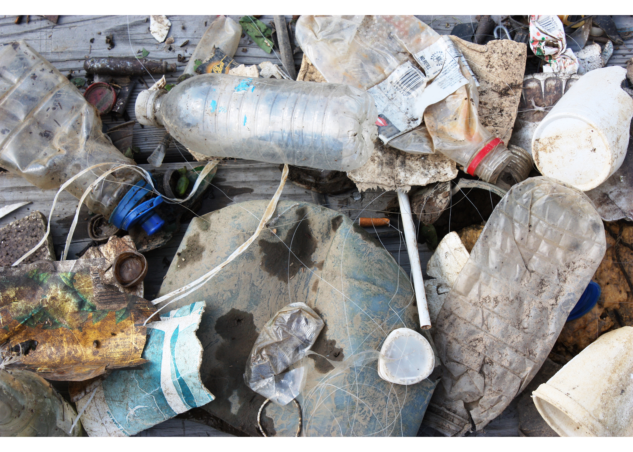 A pile of debris including plastic bottles, fishing line, and packaging.