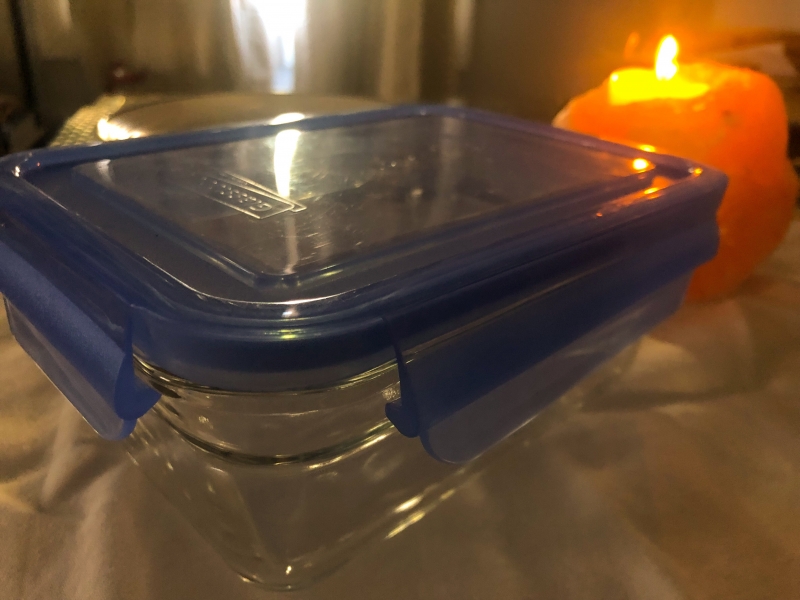A glass food container on a table. 