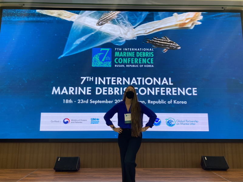 Tanya poses in front of a conference sign at the Seventh International Marine Debris Conference in Busan, South Korea.