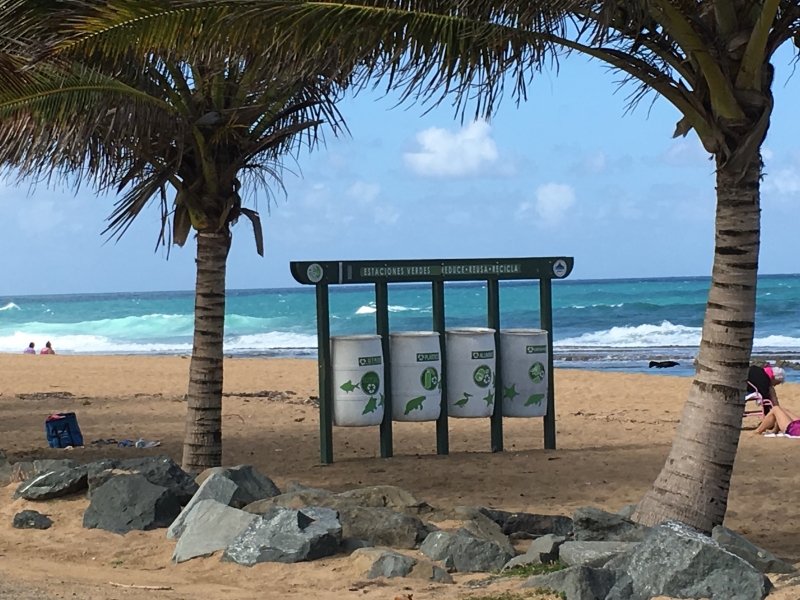 A "recycling station" with four recycling bins on the beach.