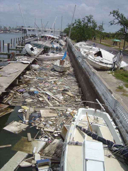 A marine with damaged boats and debris in the water.