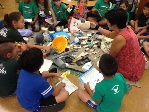 Kids in a circle, engaged in a lesson about marine debris.