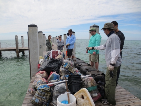 Volunteers sort collected debris on a dock in Florida.