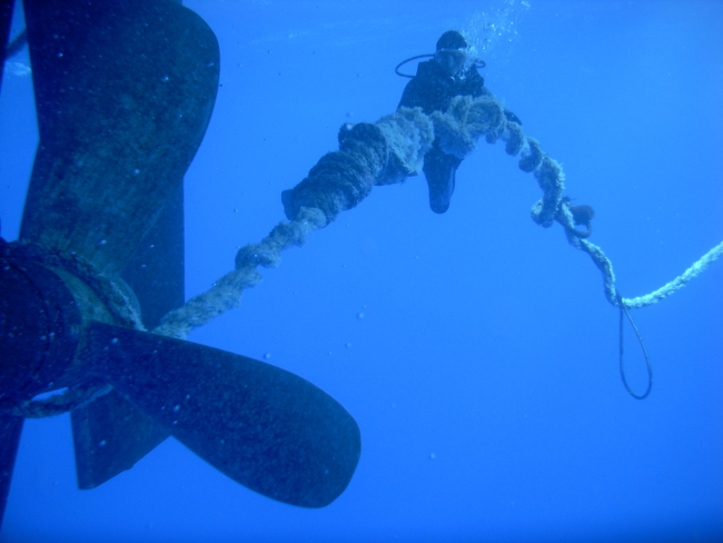 A large derelict rope caught in a large boat propeller.
