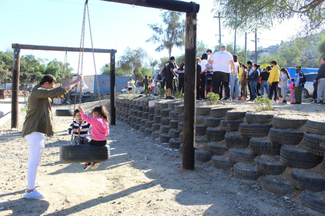 Children playing at a park made of repurposed tires. 