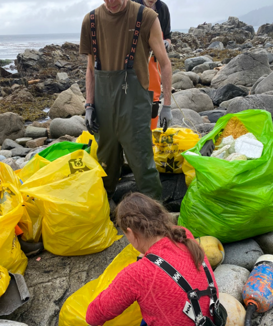 Alaska Department of Fish and Game crews gathering debris for packing into super sacks.