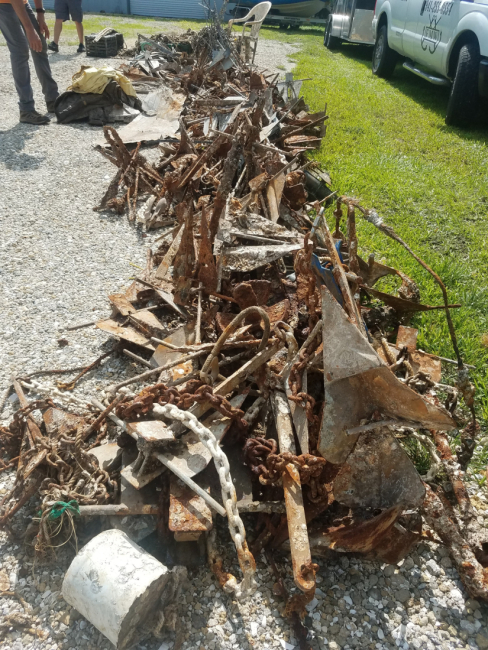 A large pile of old anchors lined up along a driveway.