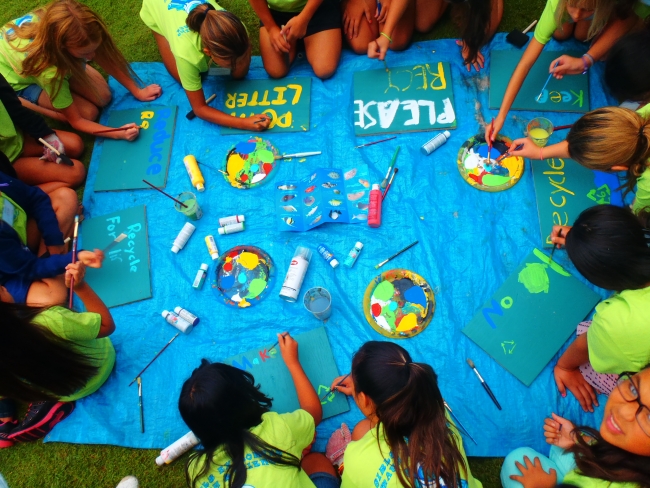 Kids creating signs that say not to litter.