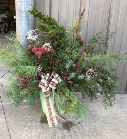 A holiday bouquet made of evergreen branches, pinecones, and other natural materials.