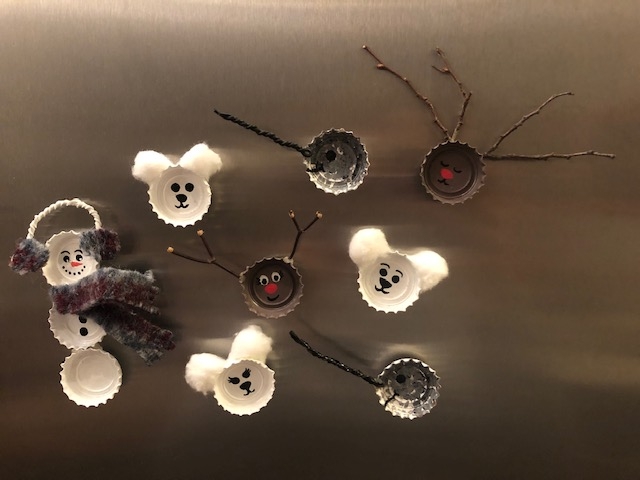 Bottle caps are painted white and glued to magnets to create snowmen or painted brown to look like deer. 