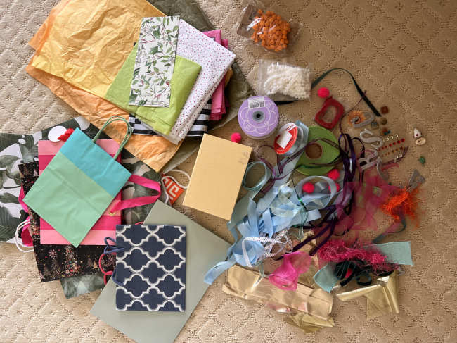 A miscellaneous pile of upcycled gift bags, tissue paper, ribbons and decorative elements.