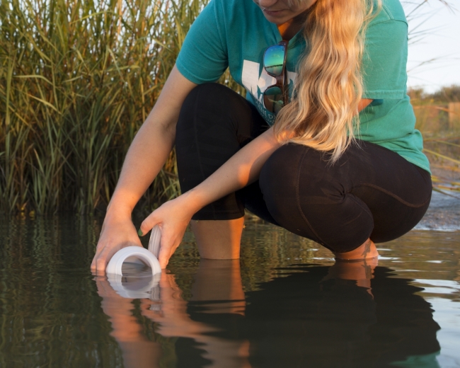 A citizen scientist collects water samples.