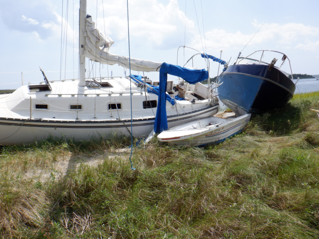 Several abandoned and derelict vessels left beached in the dunes after a hurricane.