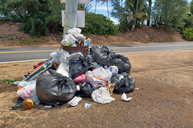 A large pile of bagged trash near a roadside in Puerto Rico.