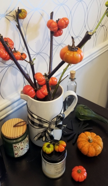 Small gourds and candles used to decorate a table.