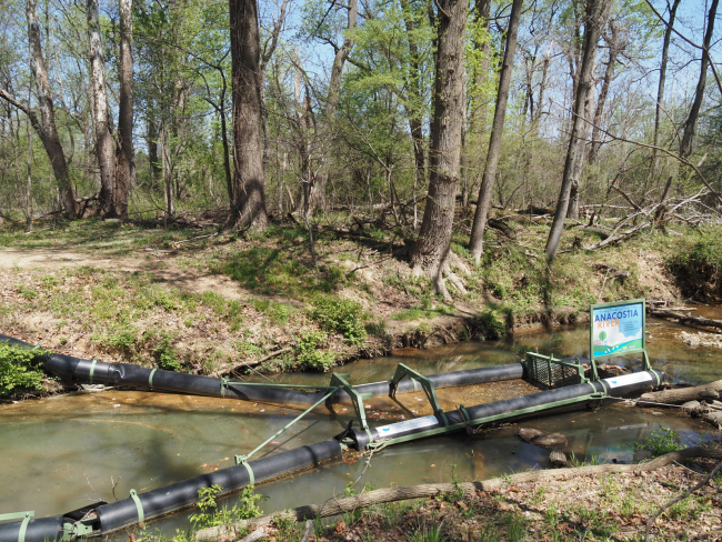 A floating litter collecting device installed in a section of river.