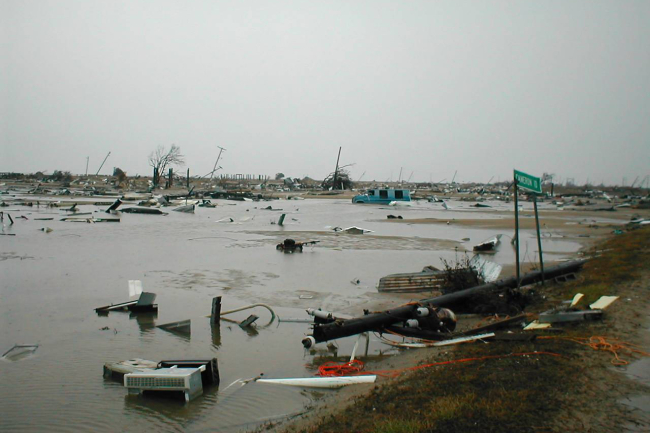 A flooded, flat area with lots of debris sitting in flood water.