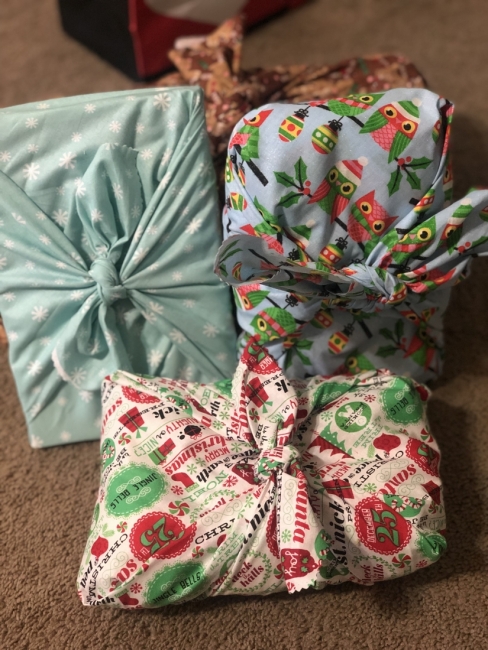 Four presents are wrapped in cloth fabric. 