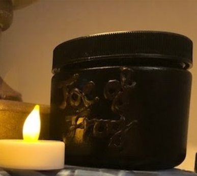 A repurposed glass jar turned into a spooky decoration with black paint and hot glue.