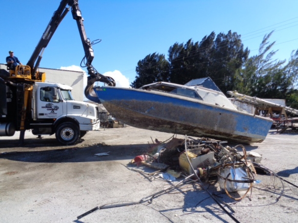 A derelict vessel being removed with equipment.