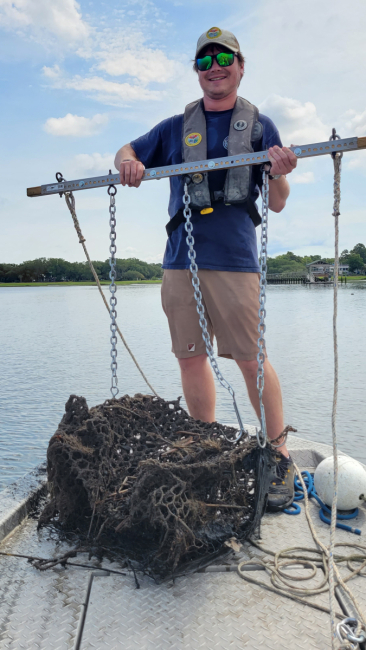 A staff member removing a derelict crab trap.