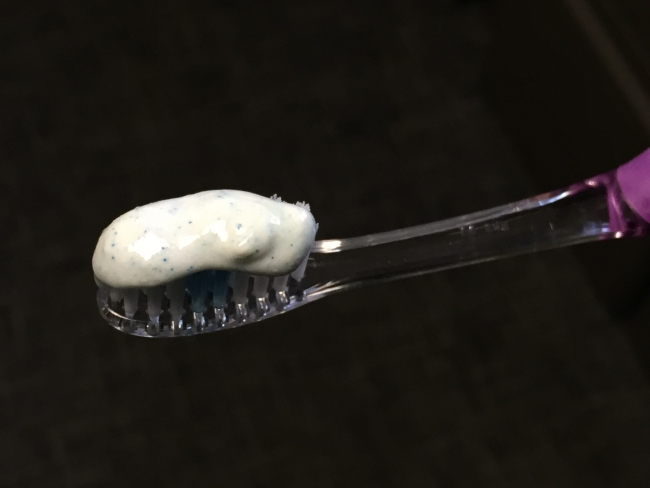 A toothbrush with toothpaste with visible microbeads in it.