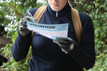 A volunteer writing on a datasheet from a marine debris cleanup event.