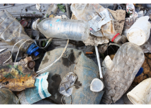 A pile of miscellaneous debris including plastic bottles, fishing line, and product packaging.