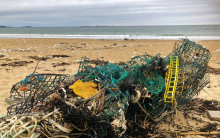 A pile of derelict fishing gear tangled together on a shoreline.