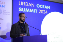 A speaker gives opening remarks on stage at the Urban Ocean Summit 2024.