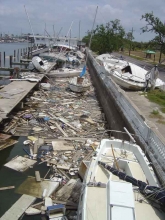 A marine with damaged boats and debris in the water.